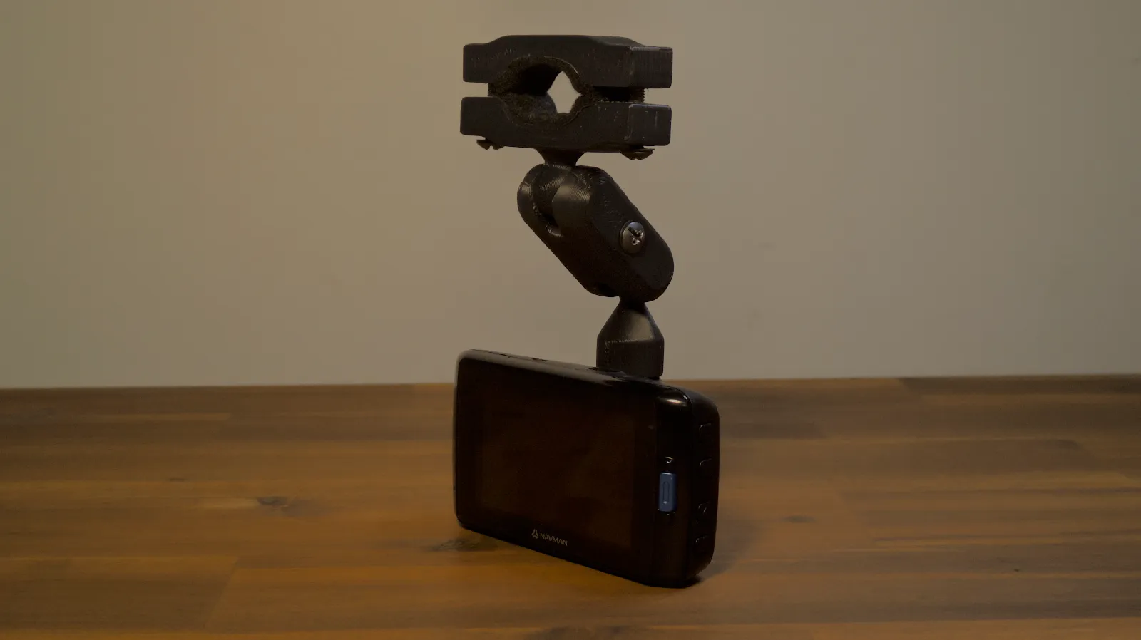 A black 3D printed adjustable mount holding a navigation device